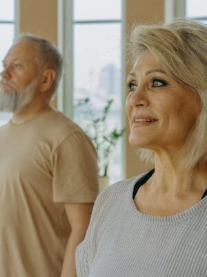 Woman in White and Black Striped Tank Top Standing Beside Man in Beige Crew Neck T